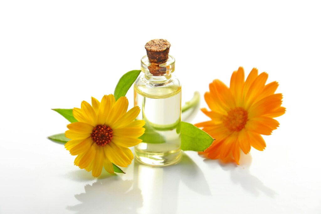 pexels-photo-932587-932587 A glass bottle of aromatic oil with chamomile flowers on a white background.